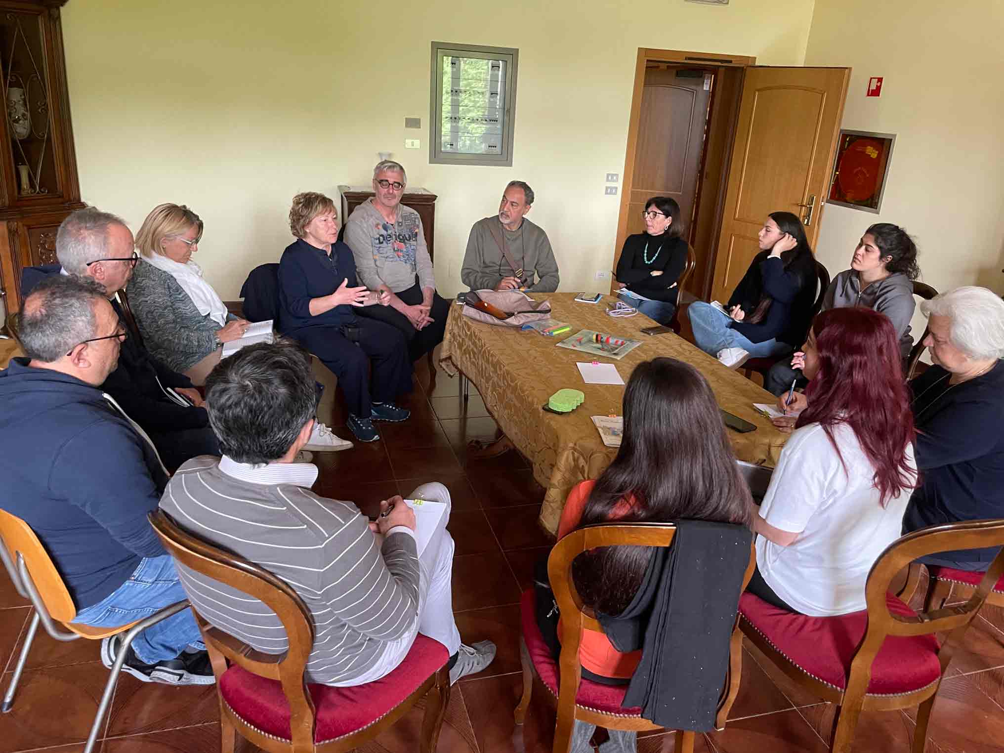 Gruppo di persone intorno al tavolo che parlano e riflettono