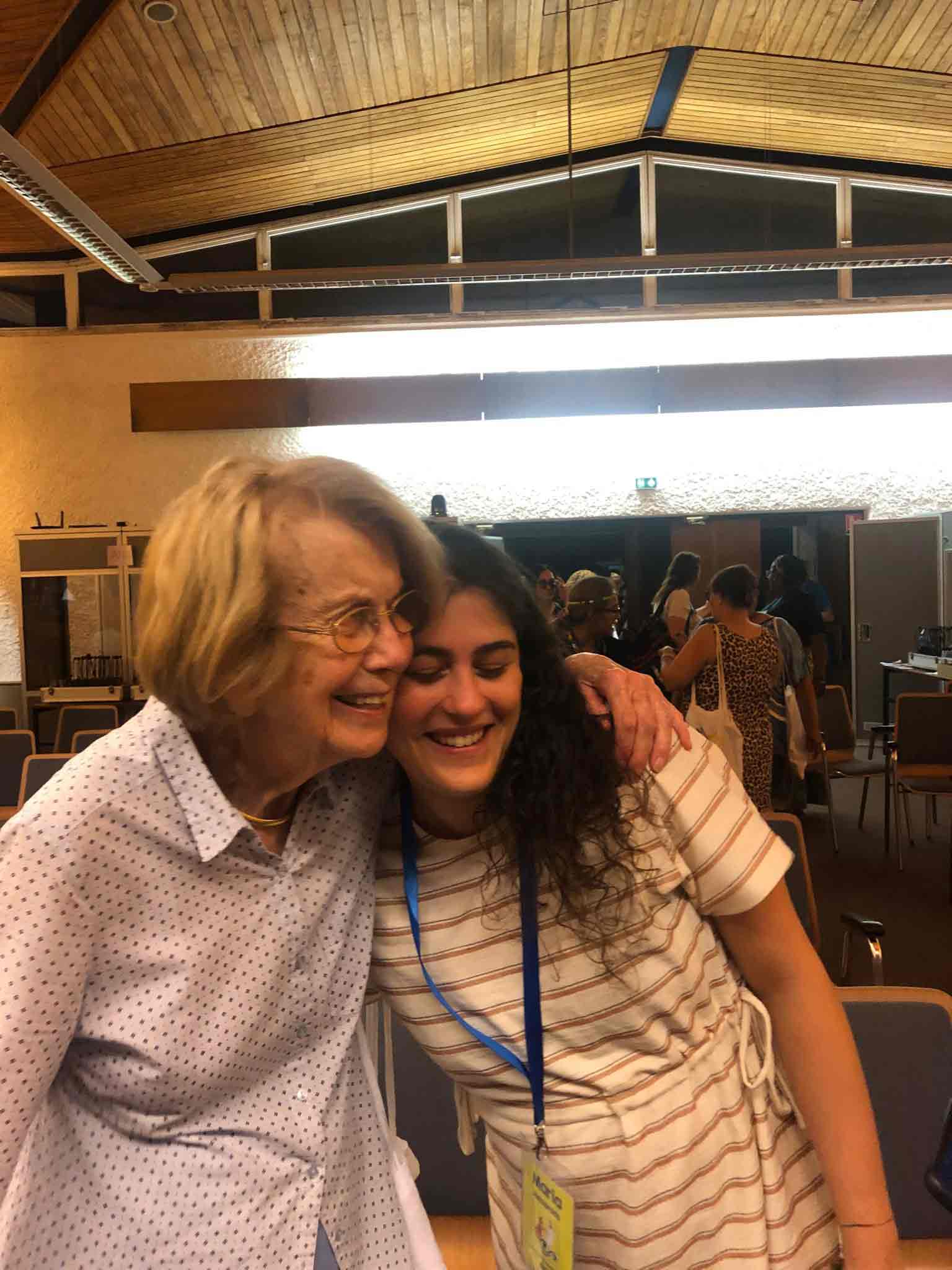 Una donna anziana e una ragazza si abbracciano sorridendo