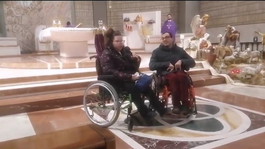 Due persone con disabilità parlano in una chiesa